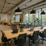 Moderne coworking-kontor med fælles arbejdsstationer, bærbare computere og grønne planter.